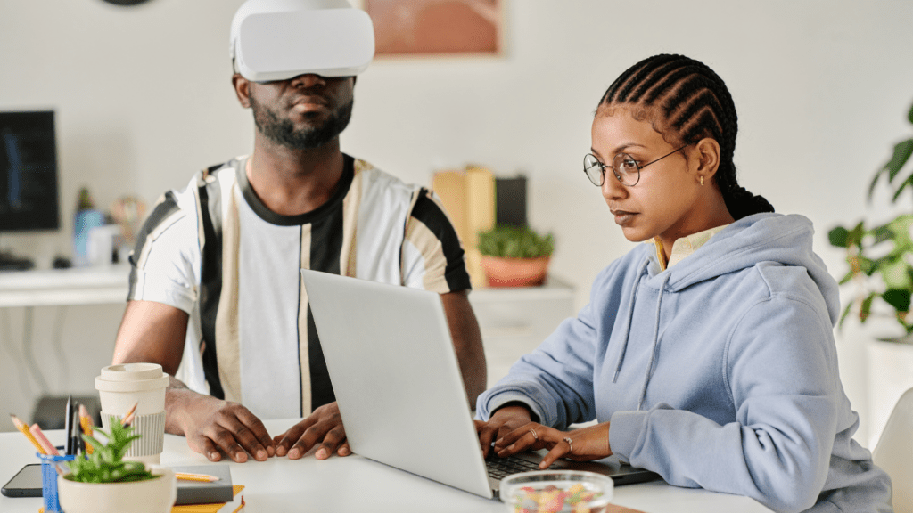 Two people wearing virtual reality glasses at a desk