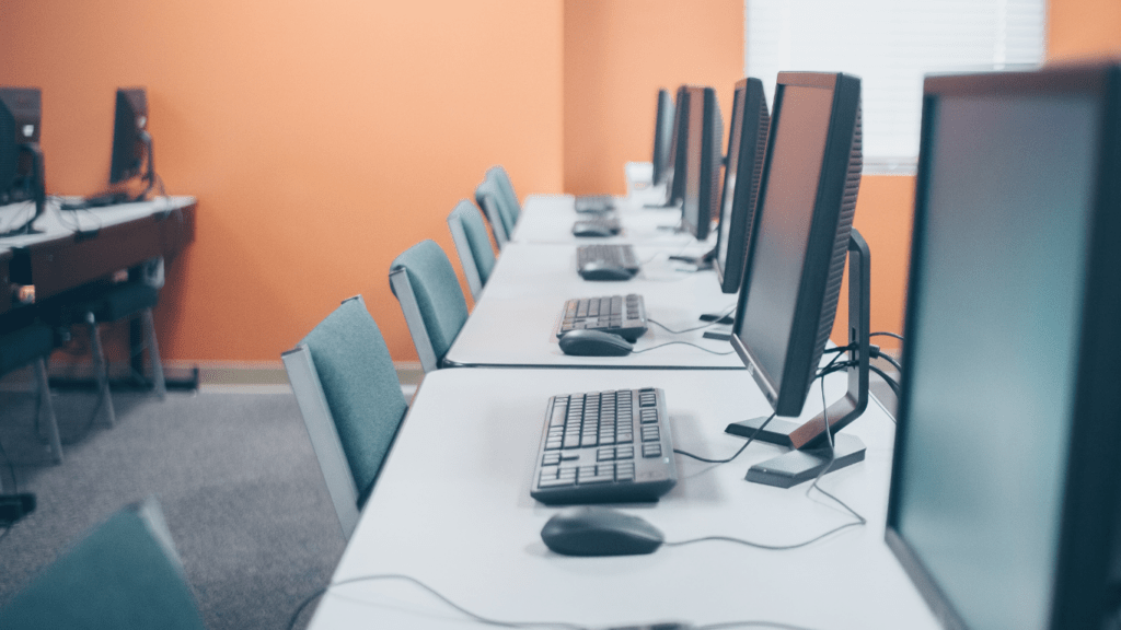 a row of computer monitors in a classroom