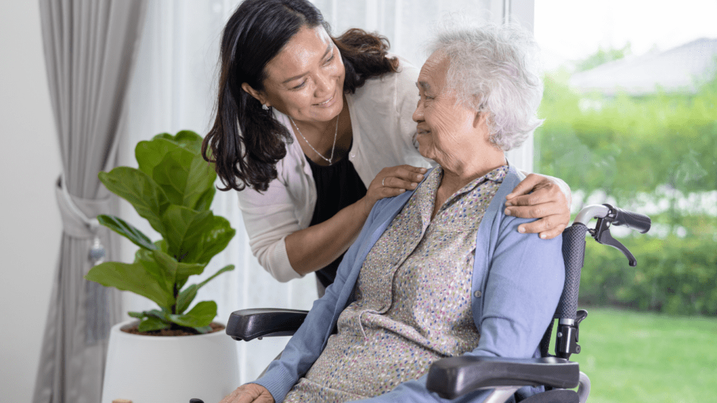 A person sitting in a wheelchair with a caregiver