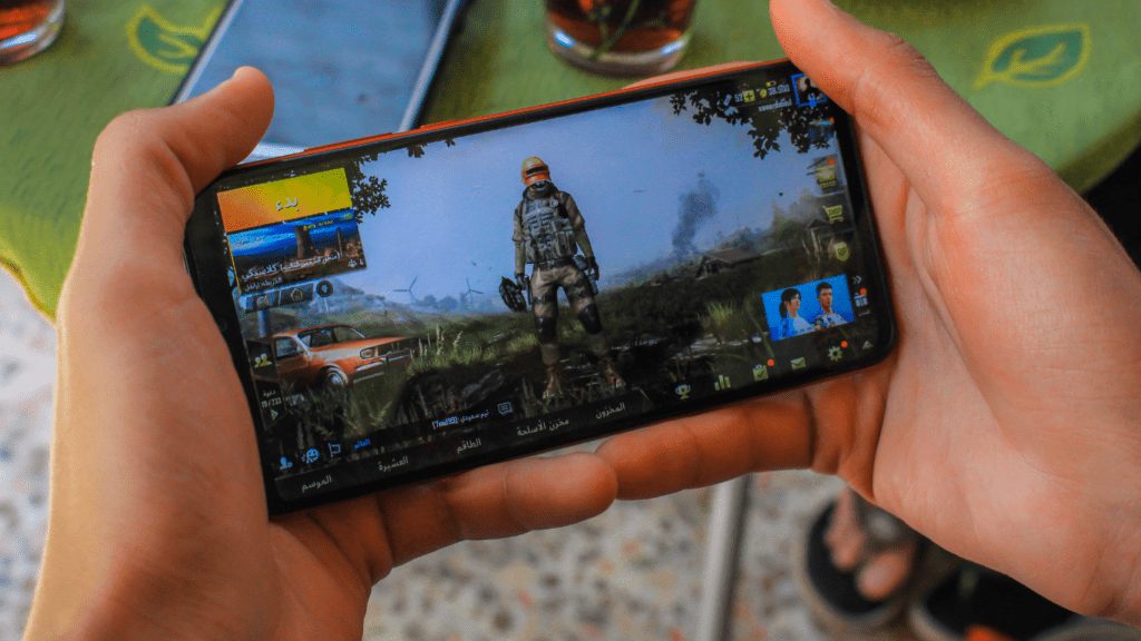 a person holding up a cell phone with a video game on it