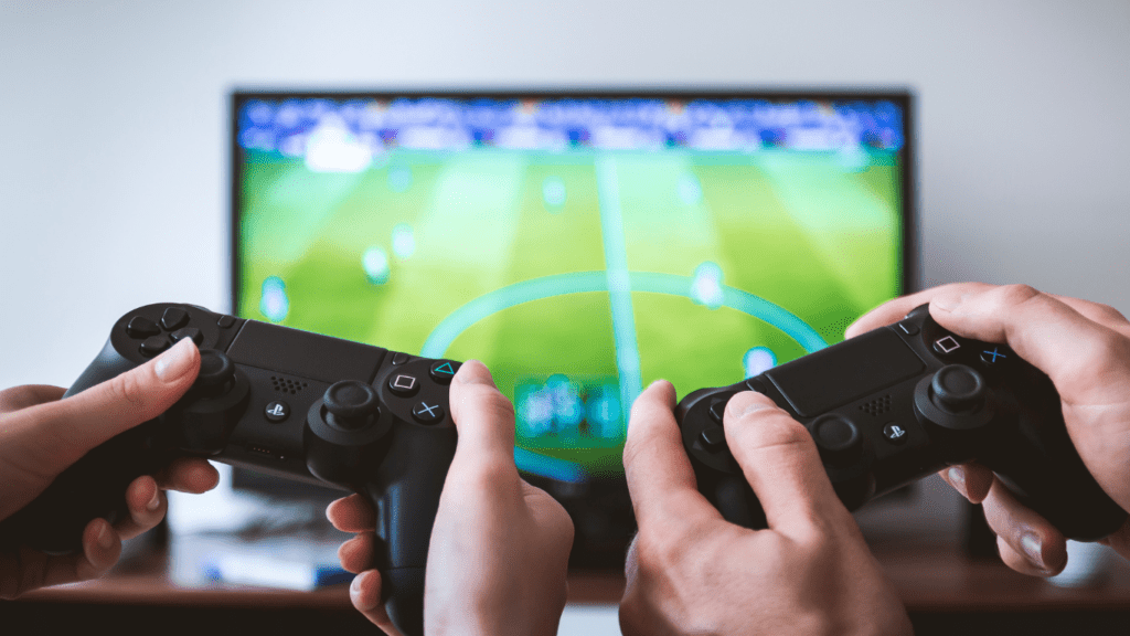 two people holding video game controllers in front of a television