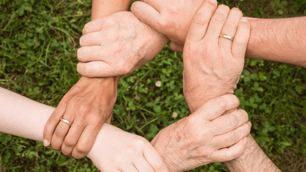 a group of business people putting their hands together