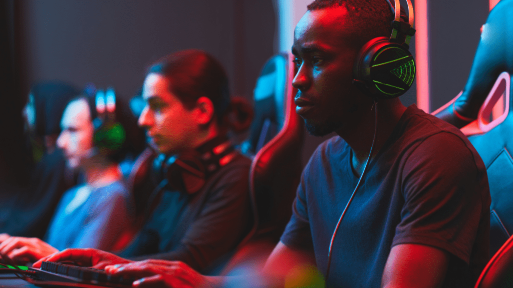 a person sitting in front of two monitors playing video games