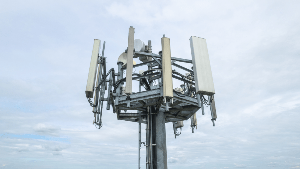 three cell phone towers against a blue sky